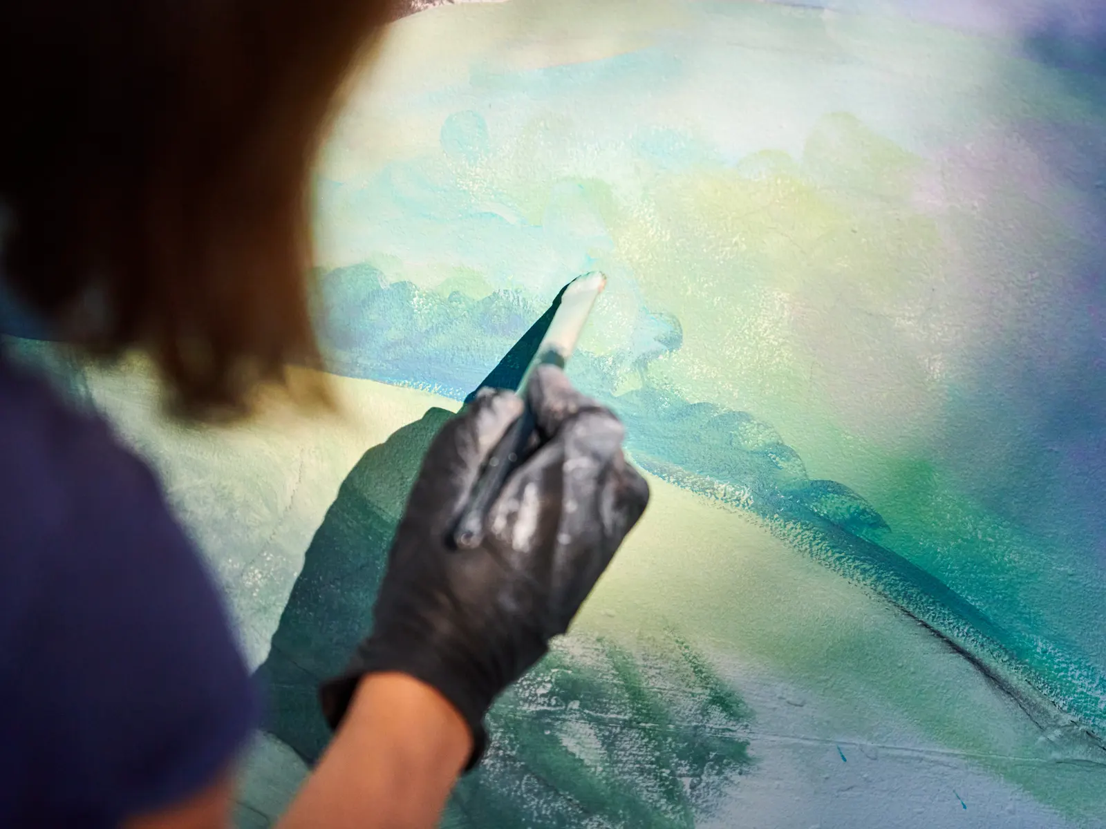 Artista che dipinge un paesaggio astratto con il pennello